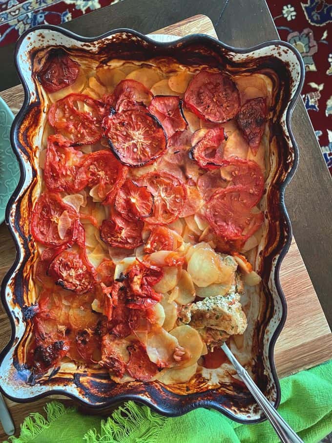 a large rectangular casserole dish of baked meat in tomatoes