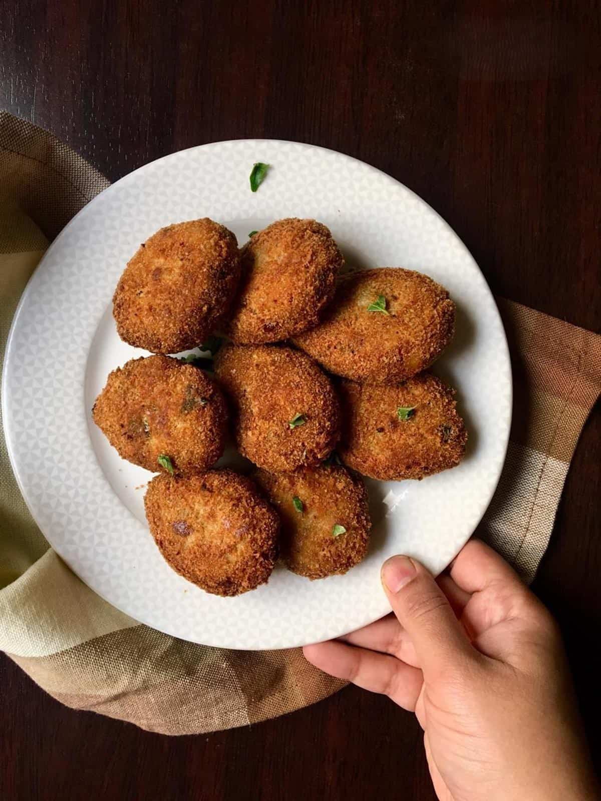 fried chicken cutlets on a white round plate