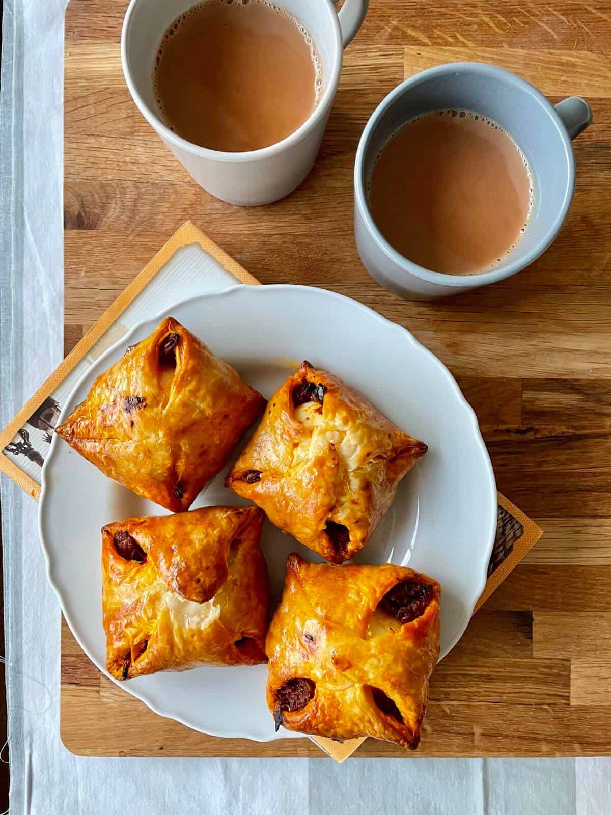 four egg puffs served with two cups of chai