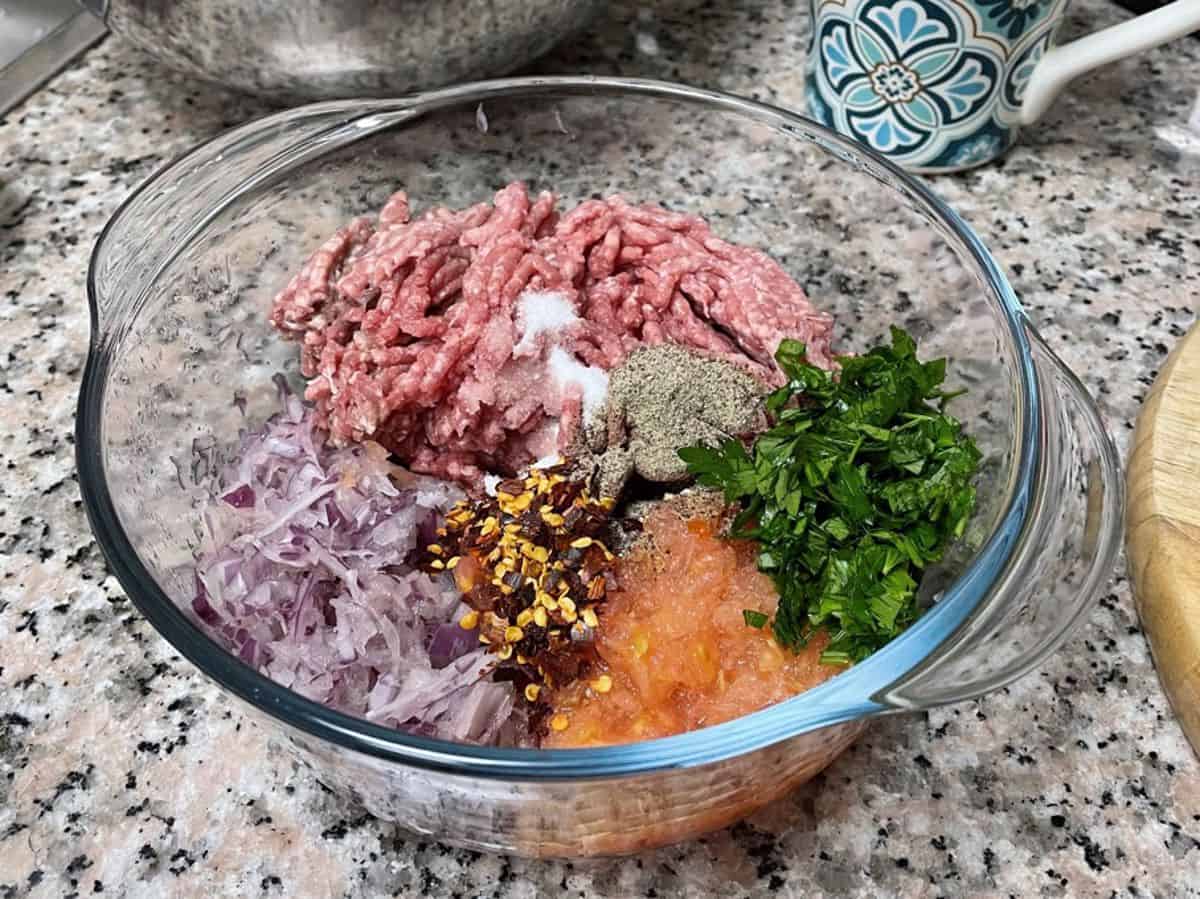 A bowl with ground meat stuffing ingredients.