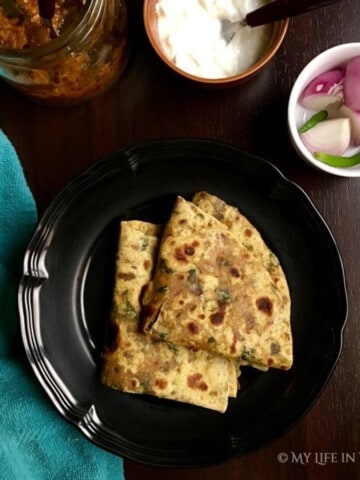 kulfa leaves paratha served with yoghurt, raw onion and lime pickle