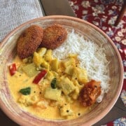 bottle gourd in yoghurt curry with white rice served in a bowl with two kerala style chicken cutlets