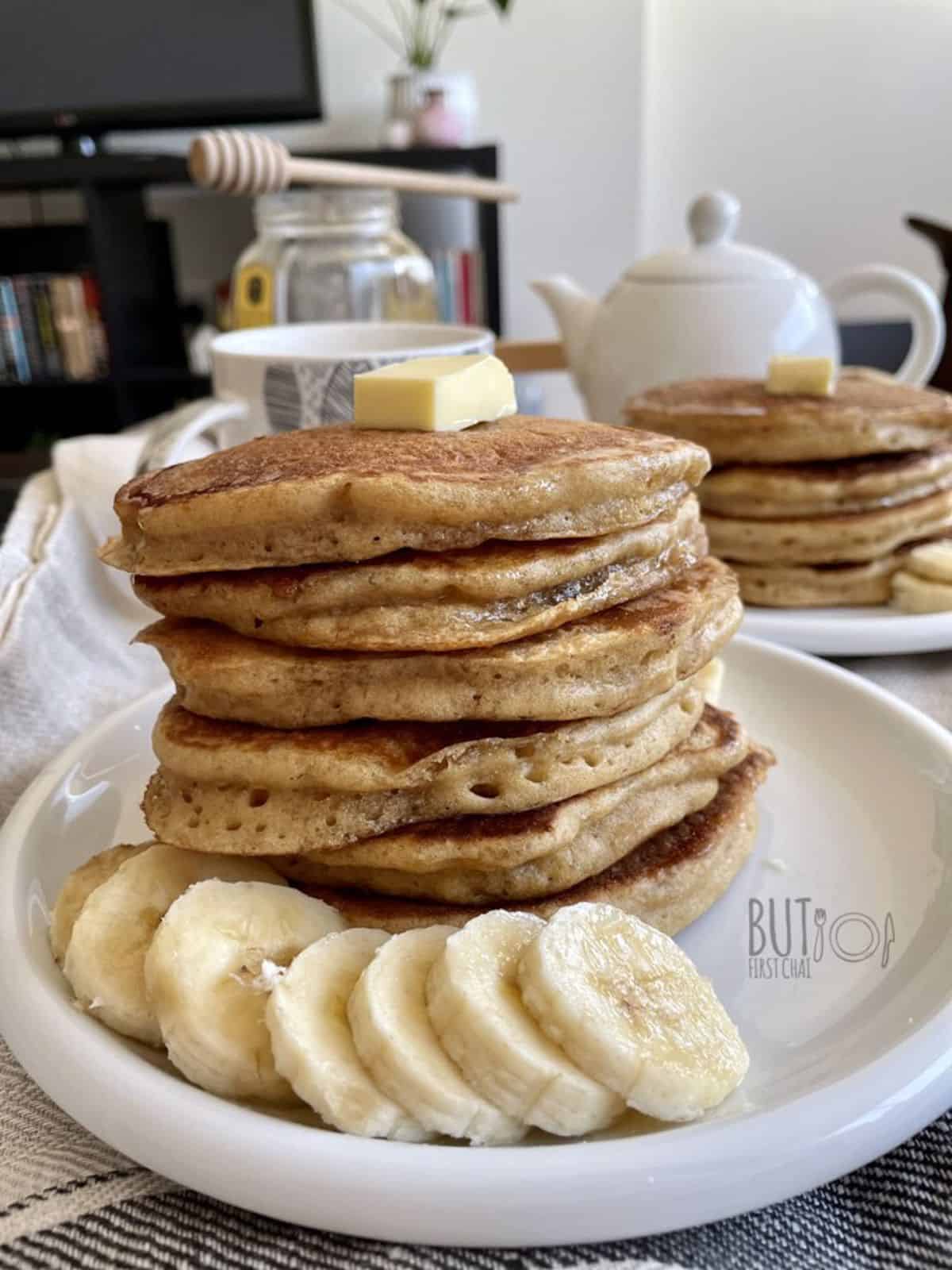 Stack of oat flour pancakes served with sliced banana