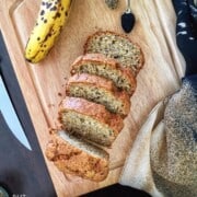 A sliced loaf of banana bread with nigella seeds
