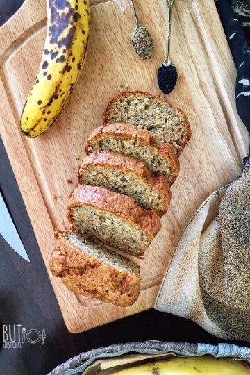 A sliced loaf of banana bread with nigella seeds