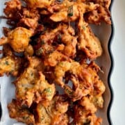 a platter of freshly fried onion fritters.