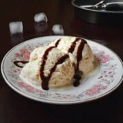 Tiny batch of pine nut ice cream scoops served with drizzle of chocolate syrup.