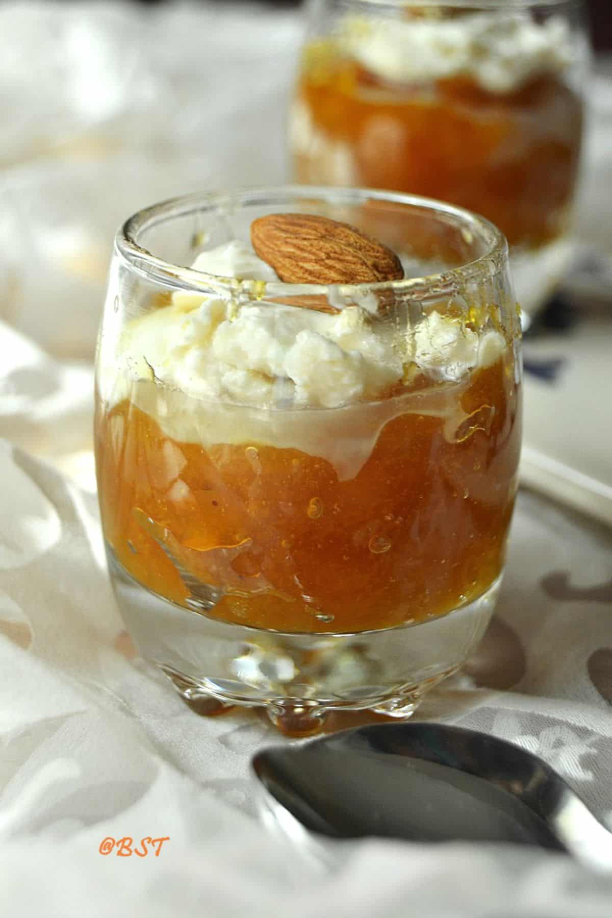 dessert cup filled with dried apricot pudding with cream.
