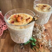 two tall glass of semiya payasam garnished with rose petals and fried cashews