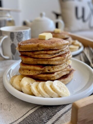 A stack of pancakes with banana slices.