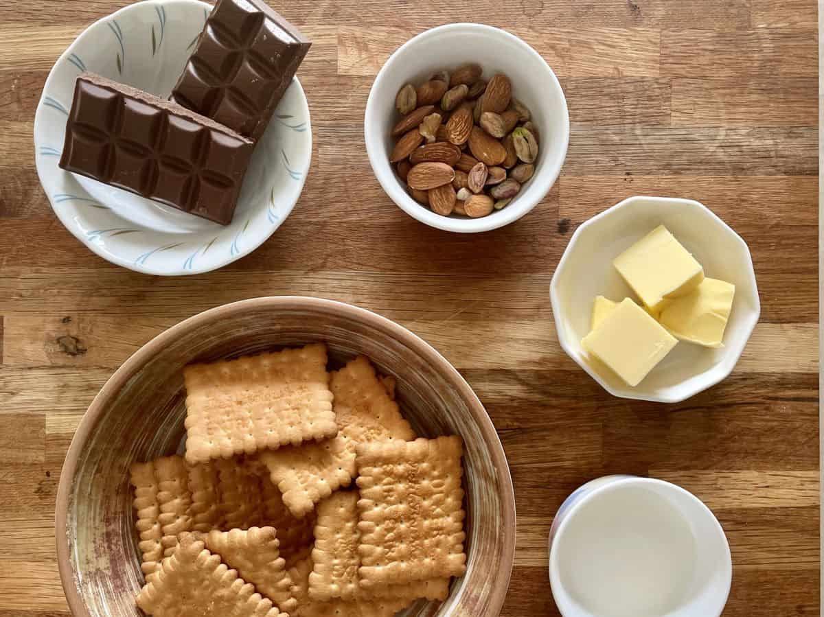 bowls of biscuits, chocolate bars, almonds, butter and milk. 