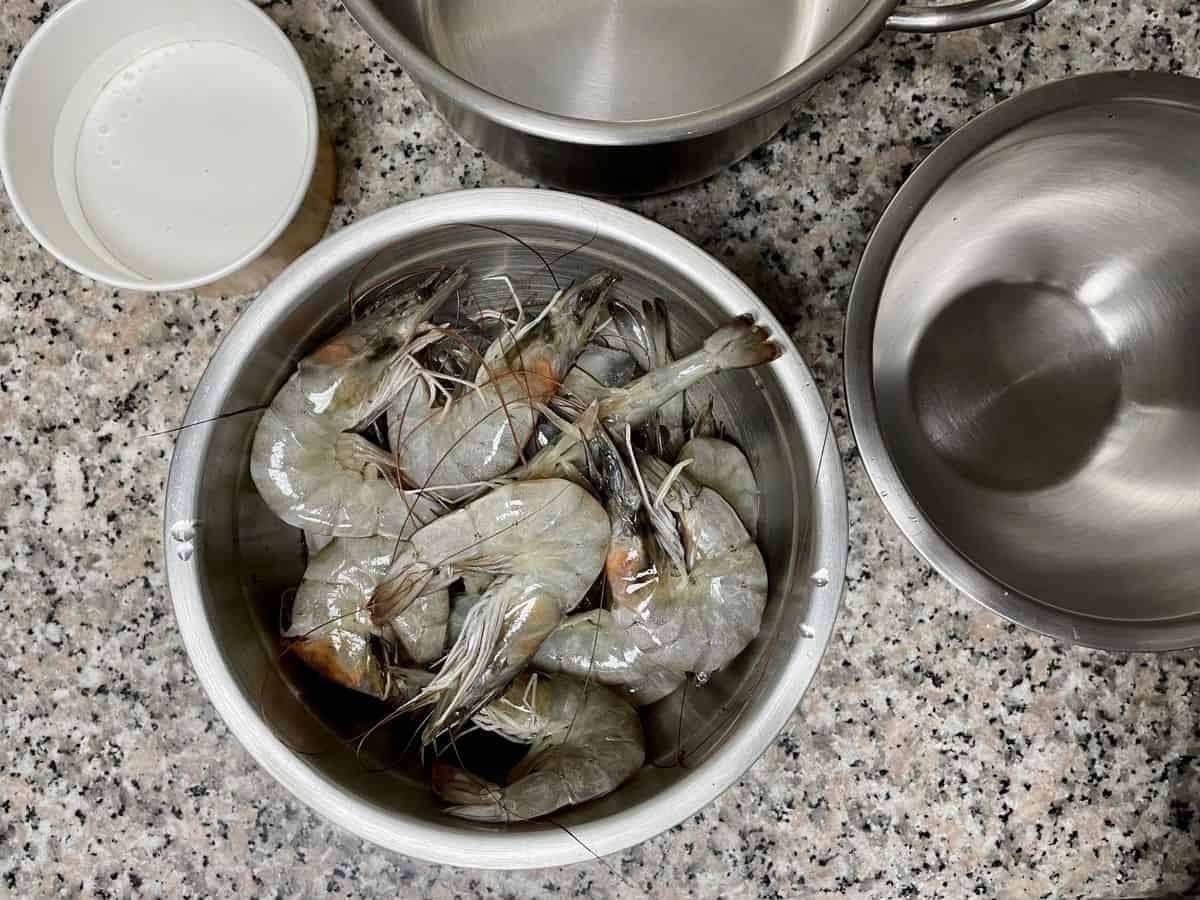 whole prawns sitting in a bowl of ice waiting to be cleaned. 
