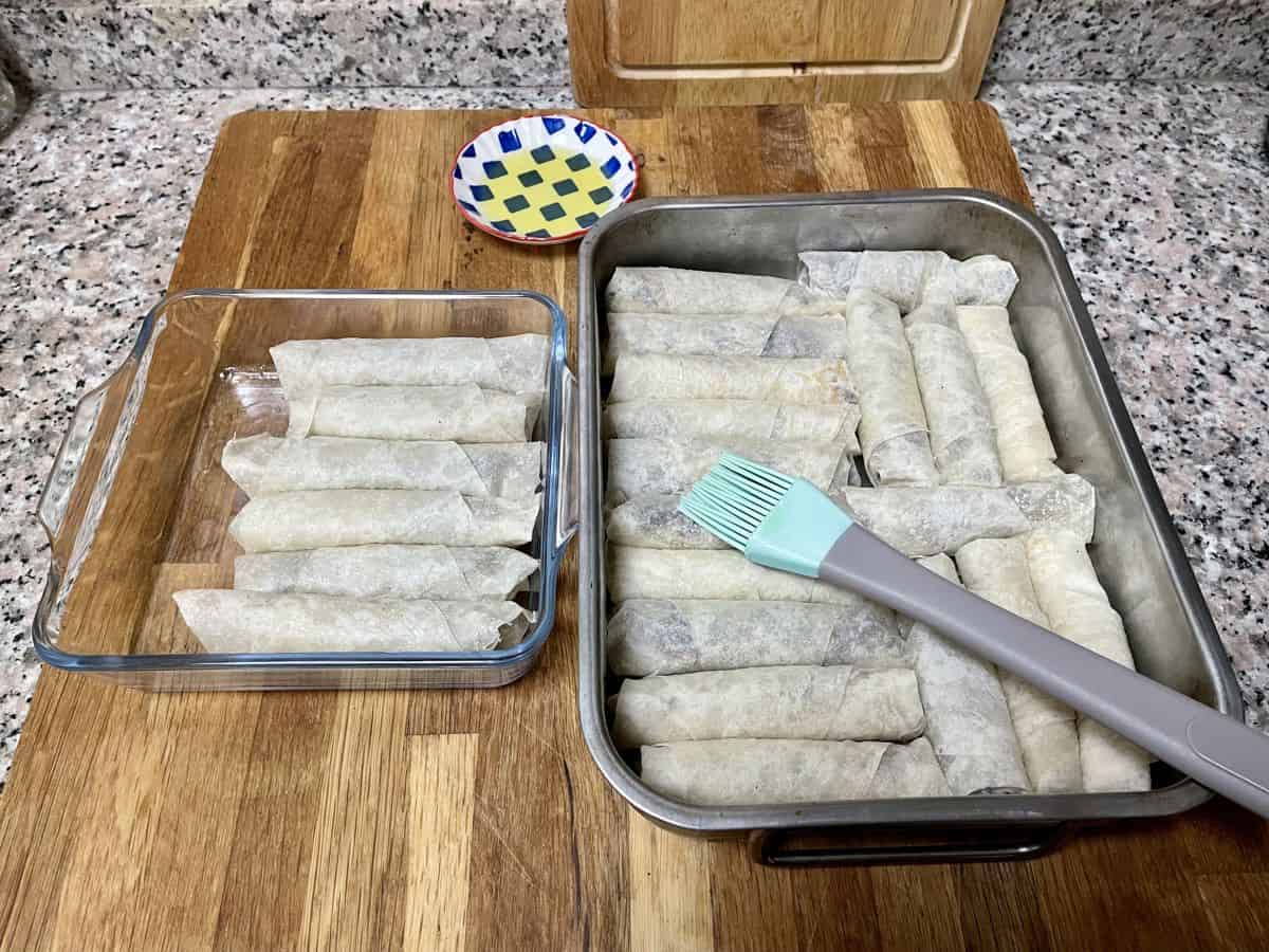 Musakhan rolls assembled in a greased baking dish and brushed with olive oil. 