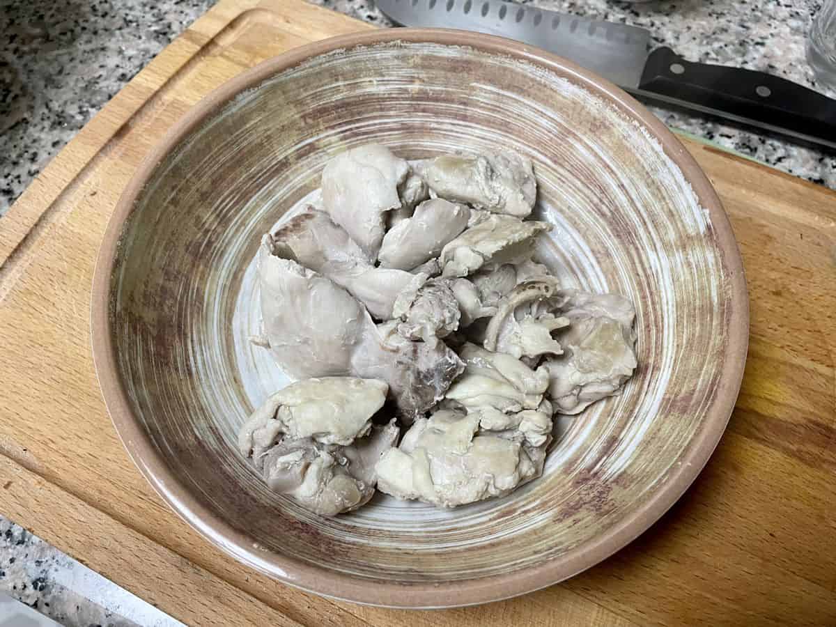Cooked boneless chicken thighs in a bowl.
