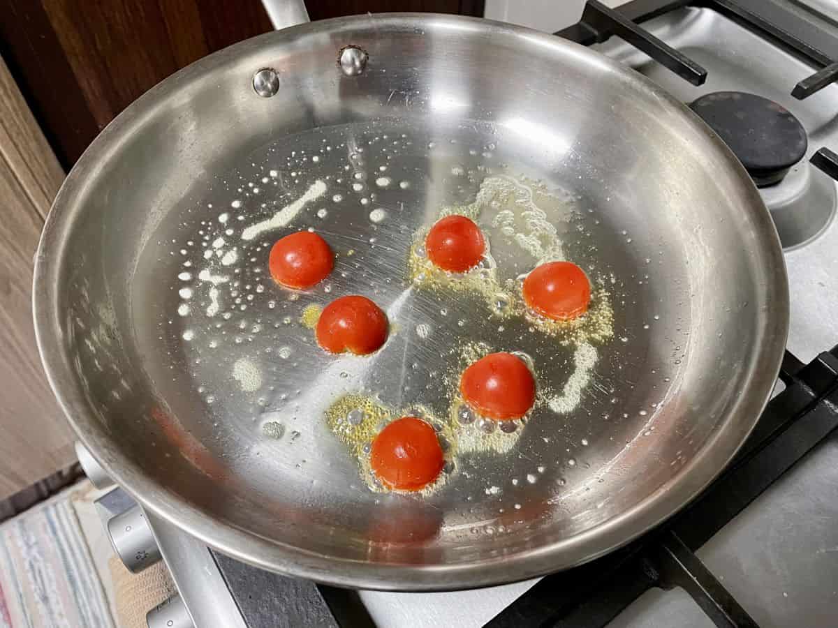 Pan with butter and cherry tomatoes cut side down.
