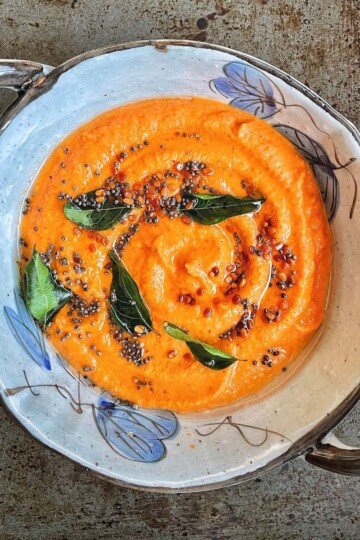 A bowl of coconut tomato chutney with freshly tempered with tadka.