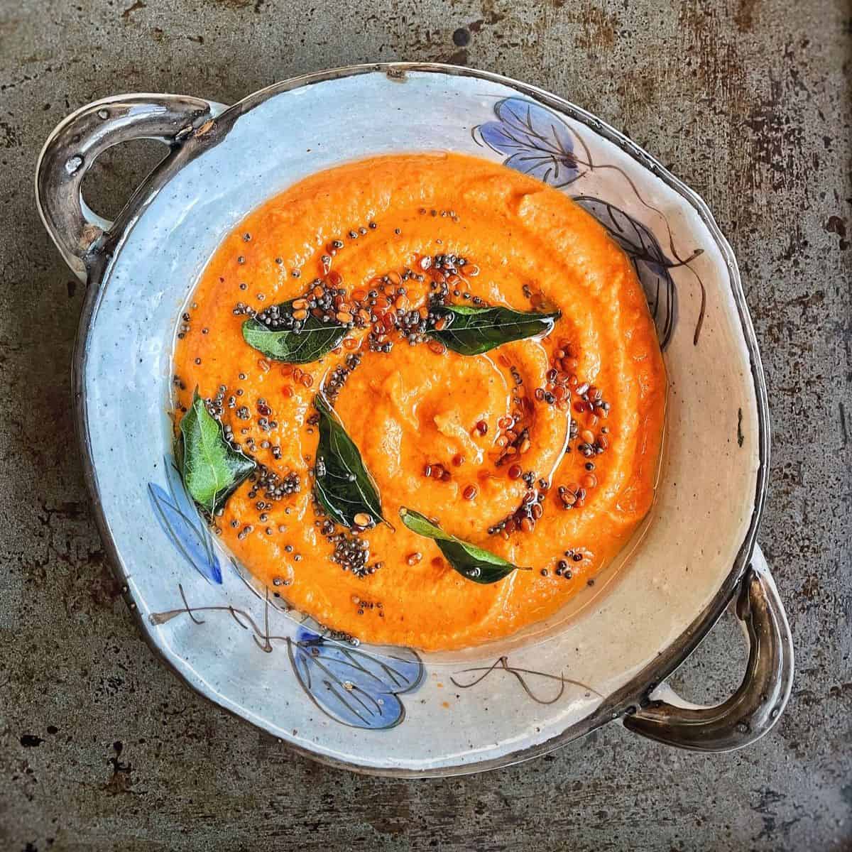A bowl of coconut tomato chutney with freshly tempered with tadka.