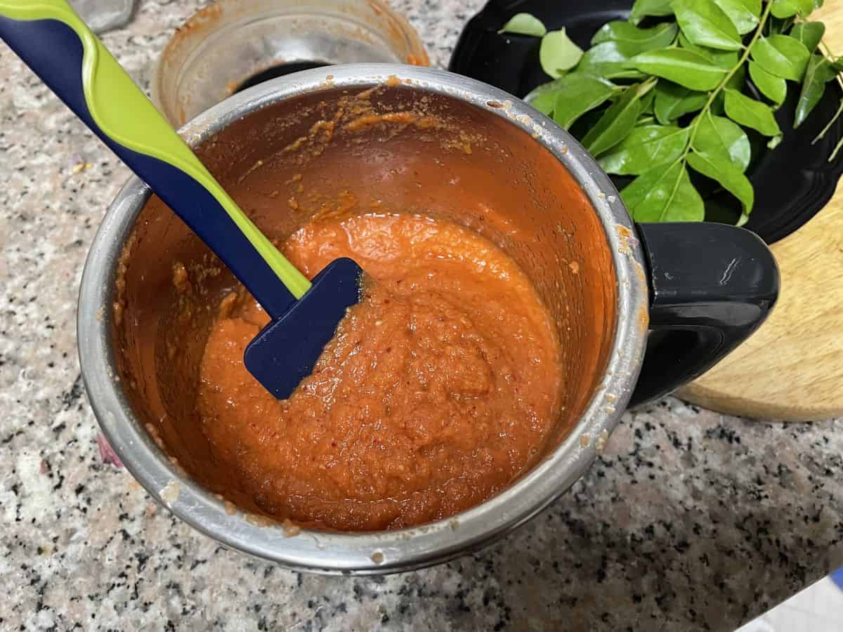 A blender with tomato chutney ingredients pureed.