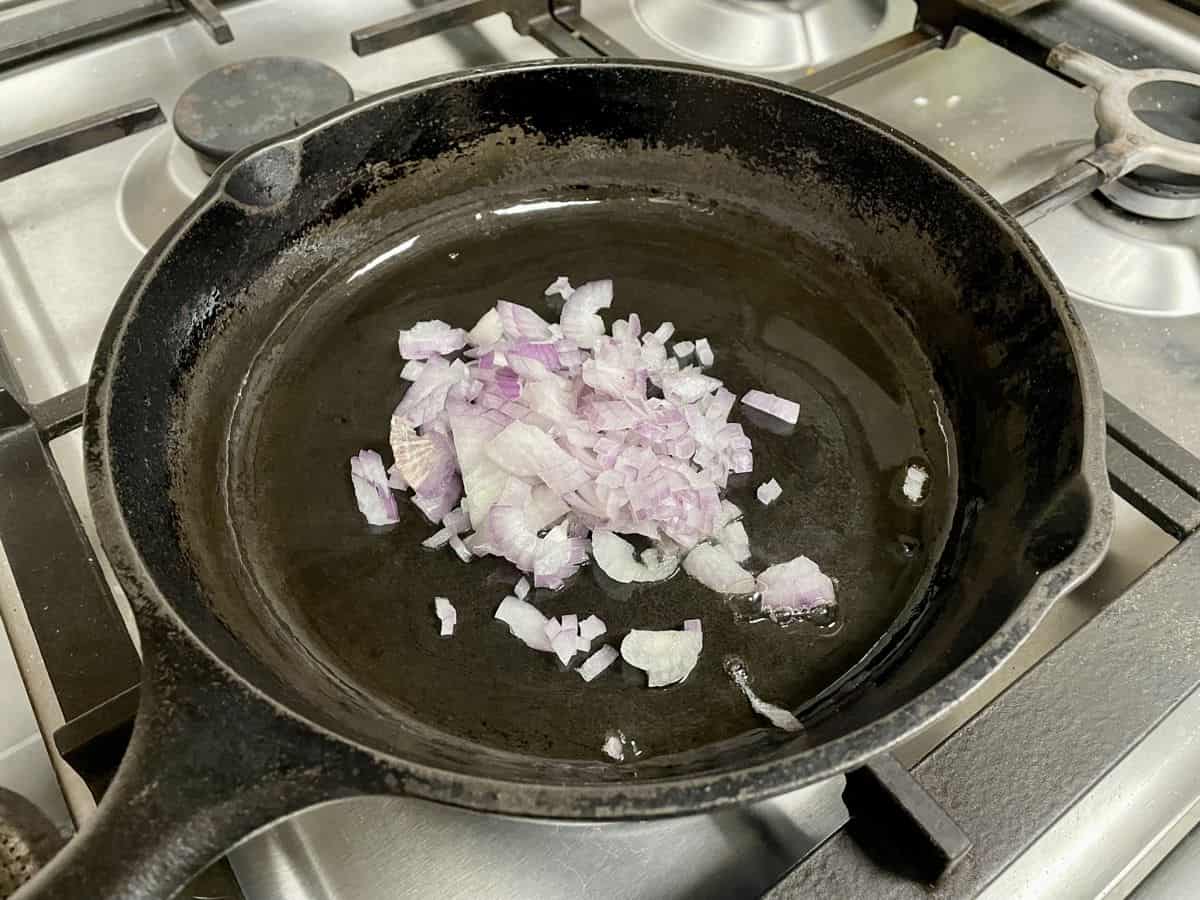 Chopped onion in cast iron skillet.