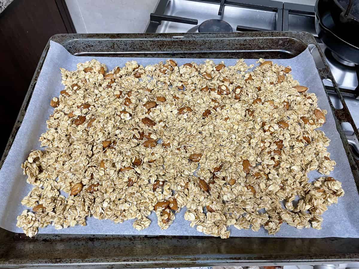 A lined baking sheet with pressed layer of oats mixture ready to be baked. 
