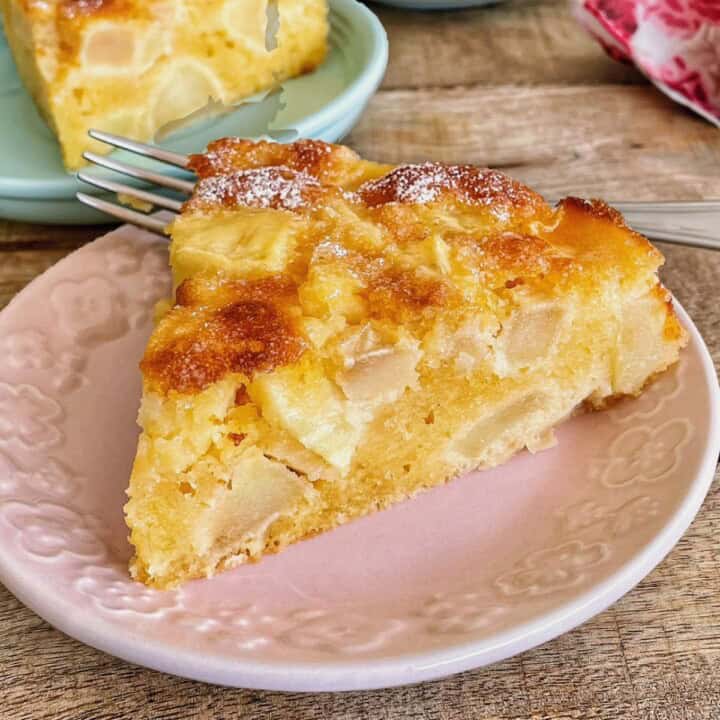 A slice of gateau pommes on a dessert plate with a fork.