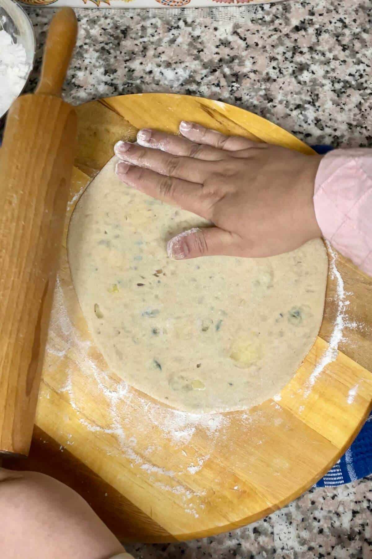 Rolling stuffed dough balls.