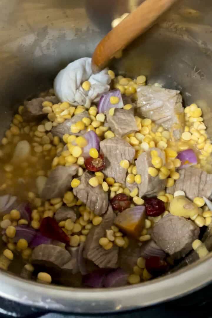 A instant pot filled with beef, chana dal and aromatics.