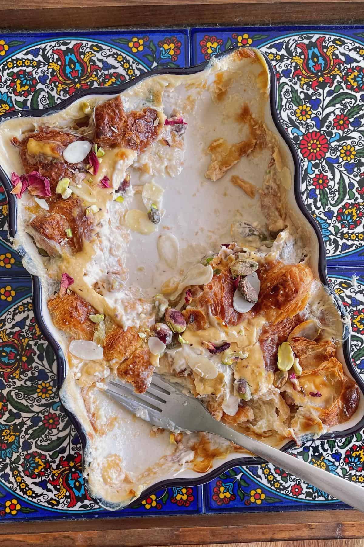 A half eaten om ali dish with a fork..