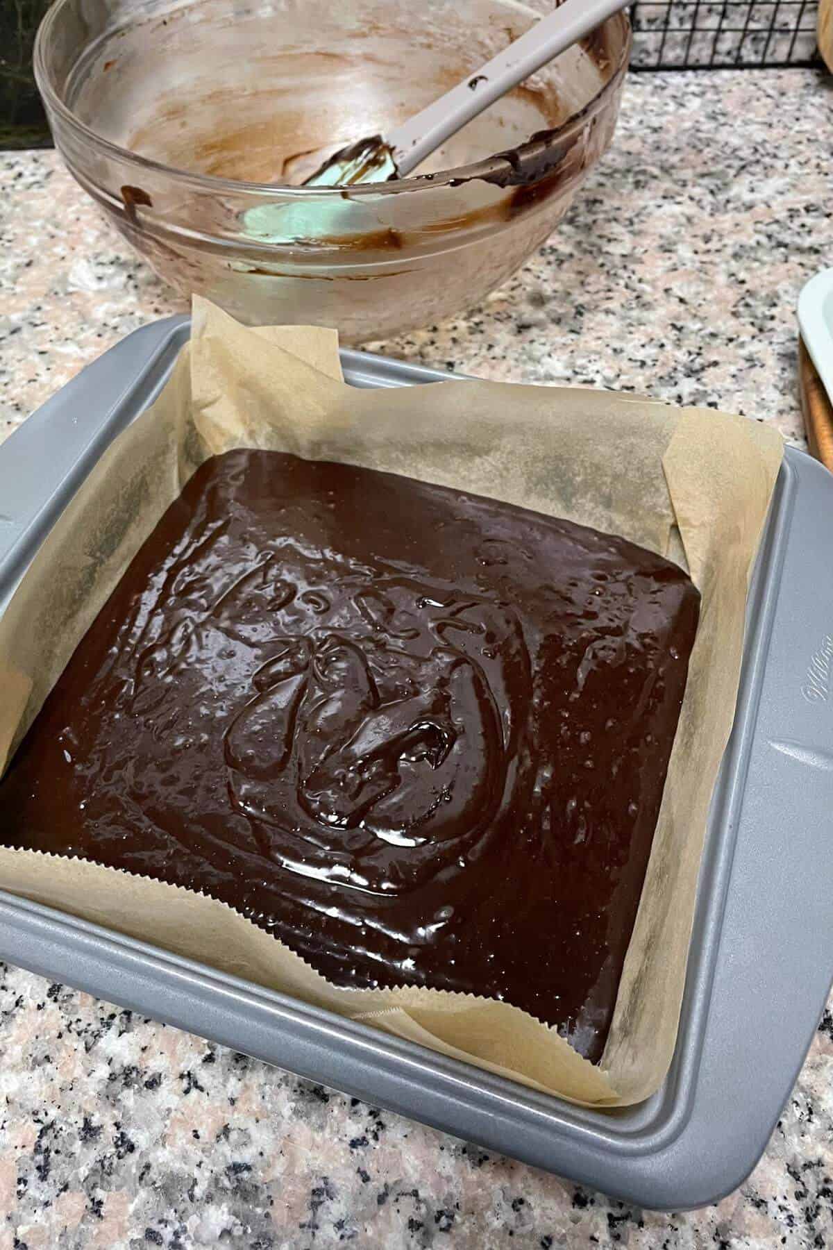 Lined brownie pan filled with double chocolate brownie batter.