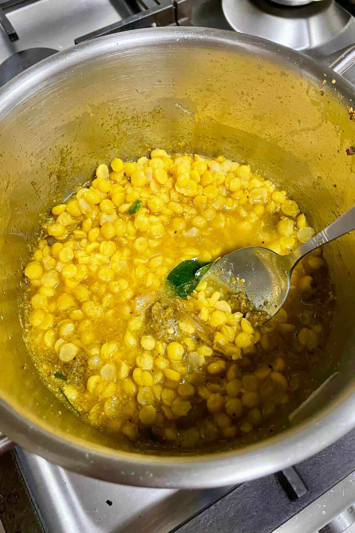 Boiled or pressure cooked chana dal with water added to the sauce pot. 