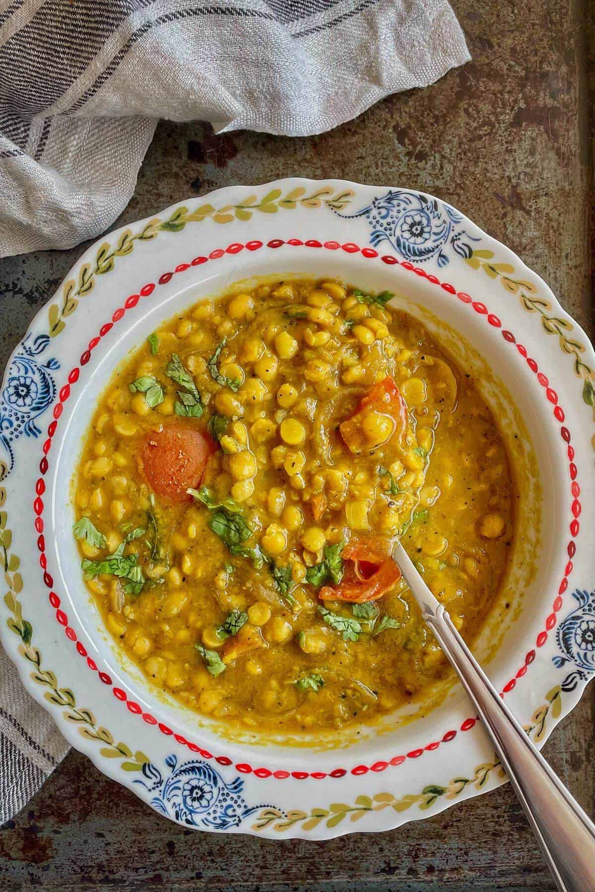 A bowl of Dal Fry with serving spoon. 