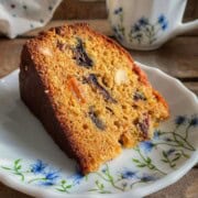 A slice of kerala plum cake on a dessert plate.