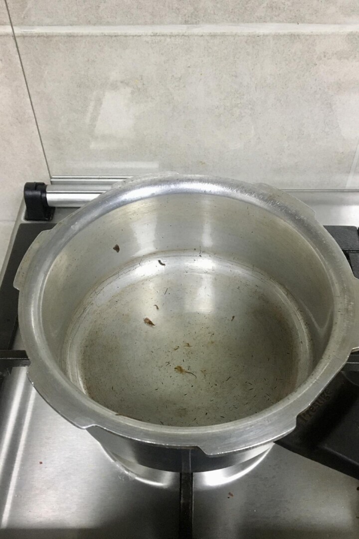 Heating the cooker pot with oil in it. 