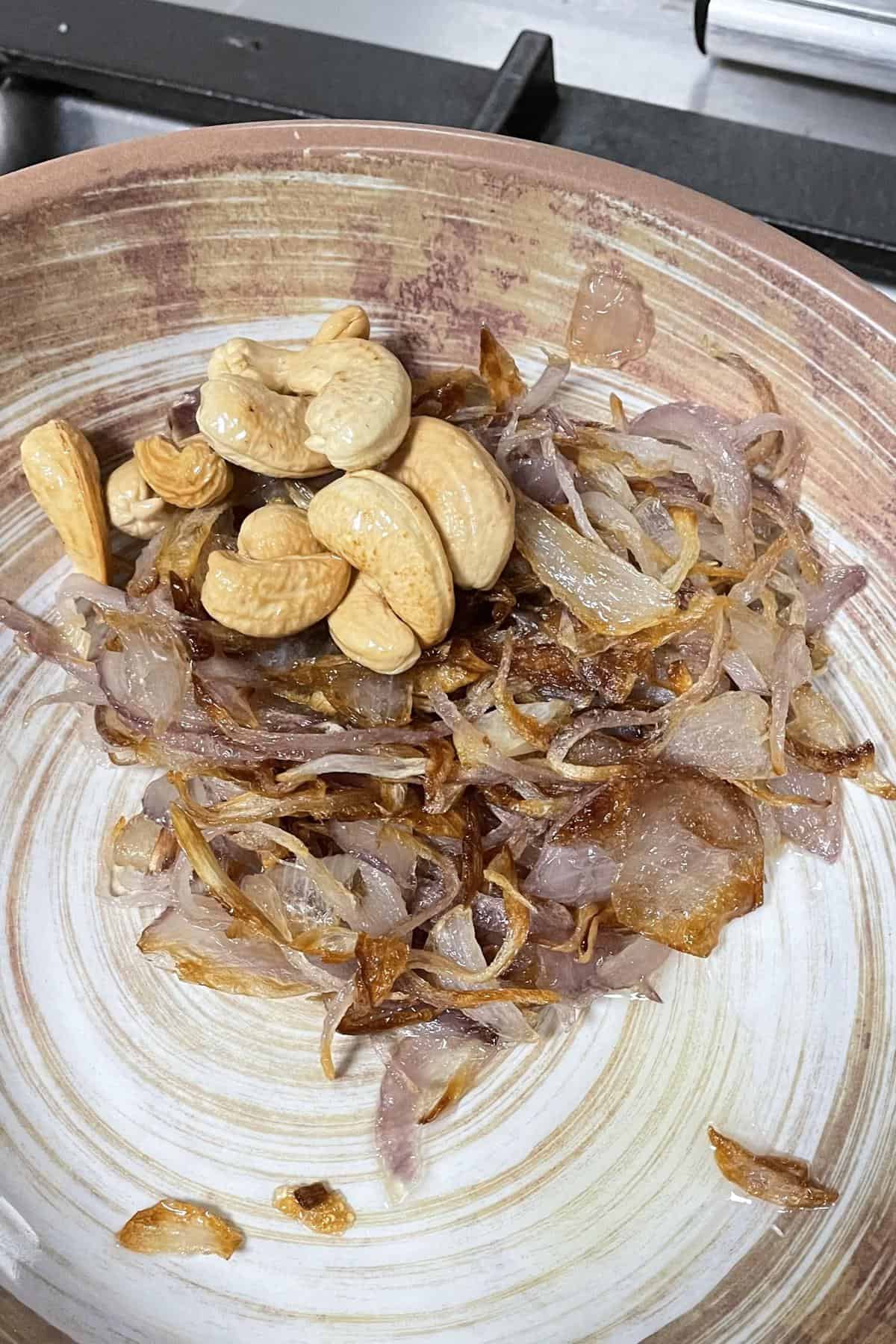 Fried cashews and onions in a bowl.
