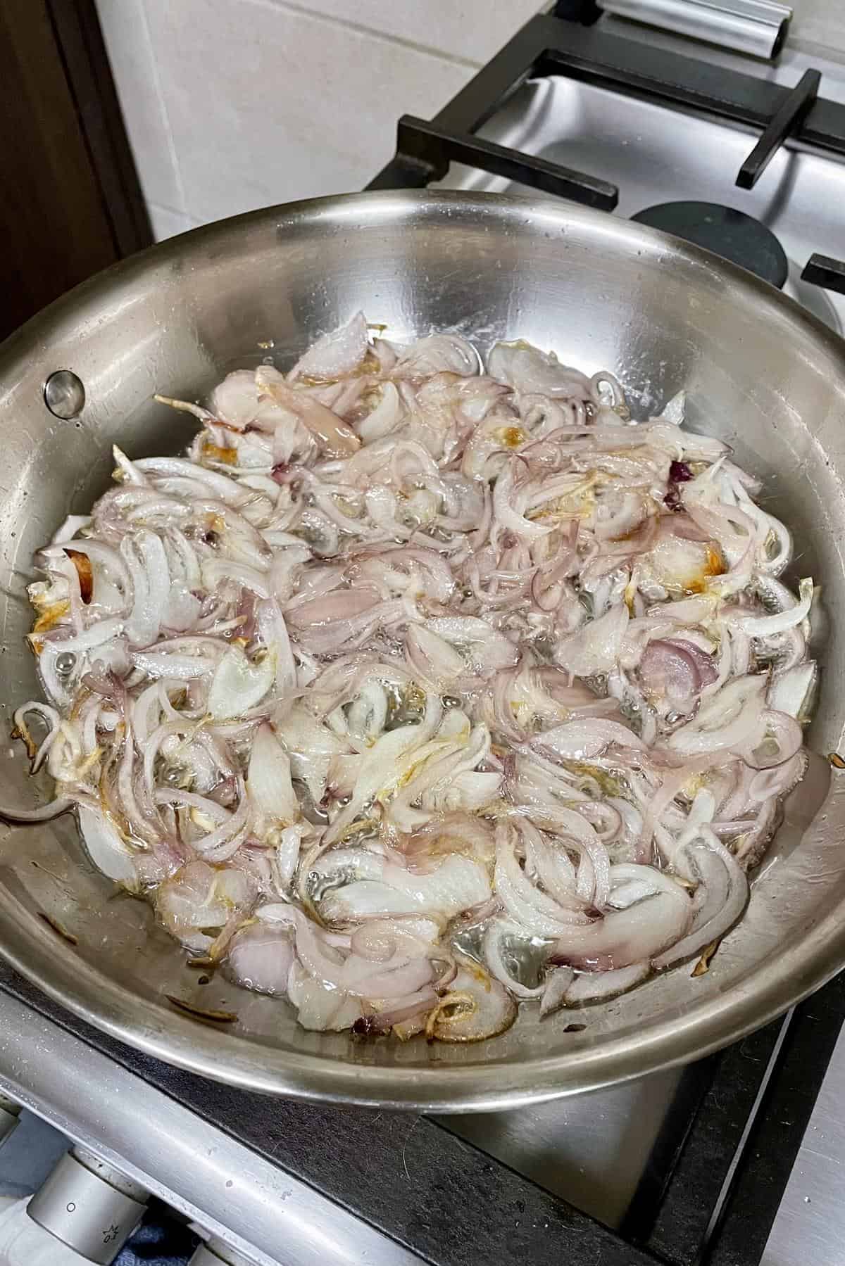 Sauteing sliced onions in a pan.
