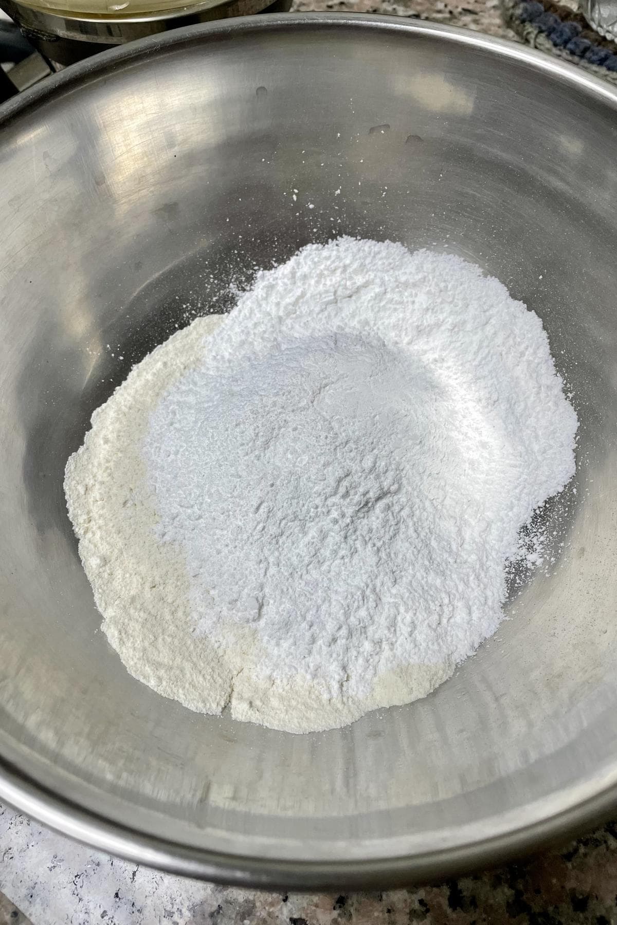 Toasted rava flour and powdered sugar in a large mixing bowl.