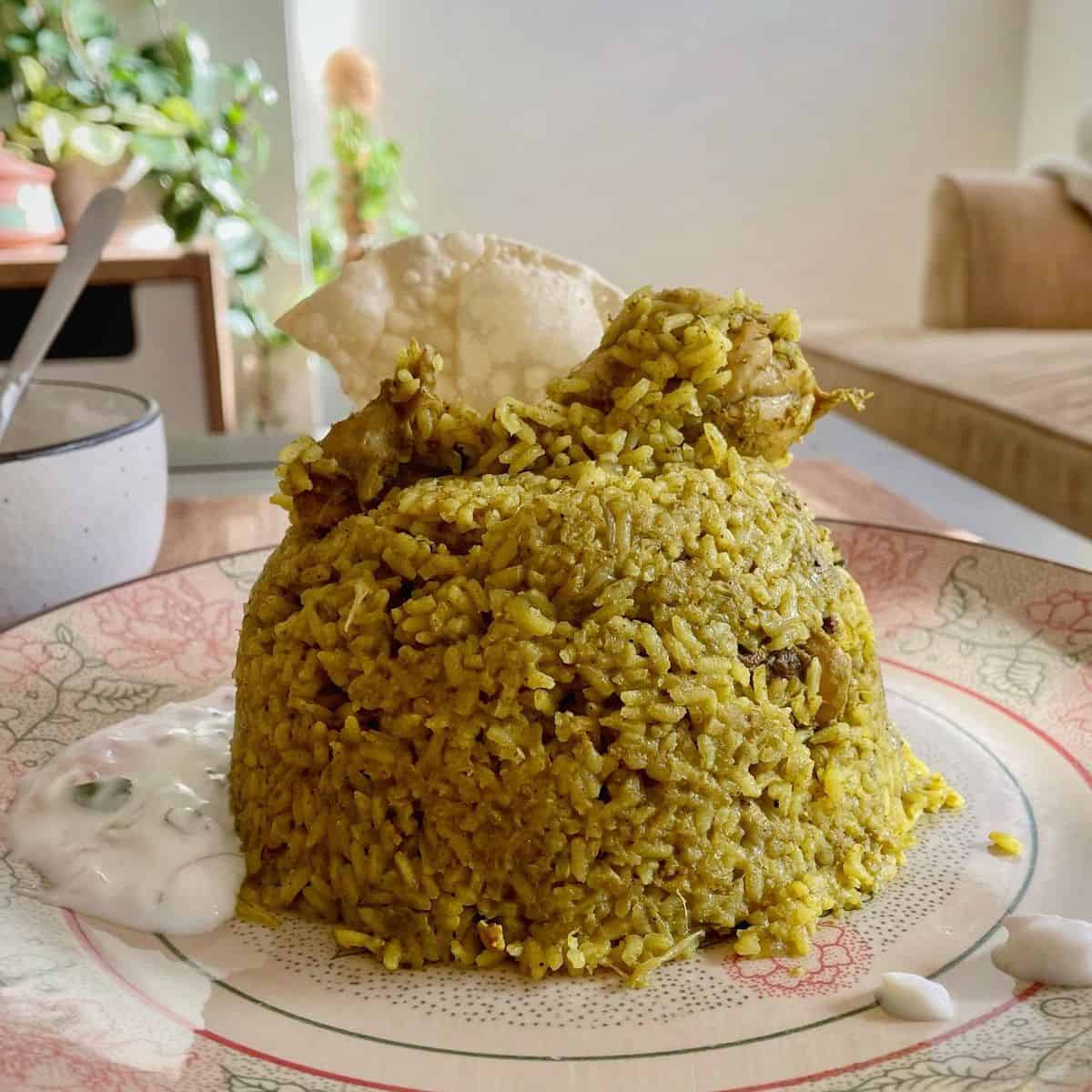 chicken donne biryani served with onion raita.