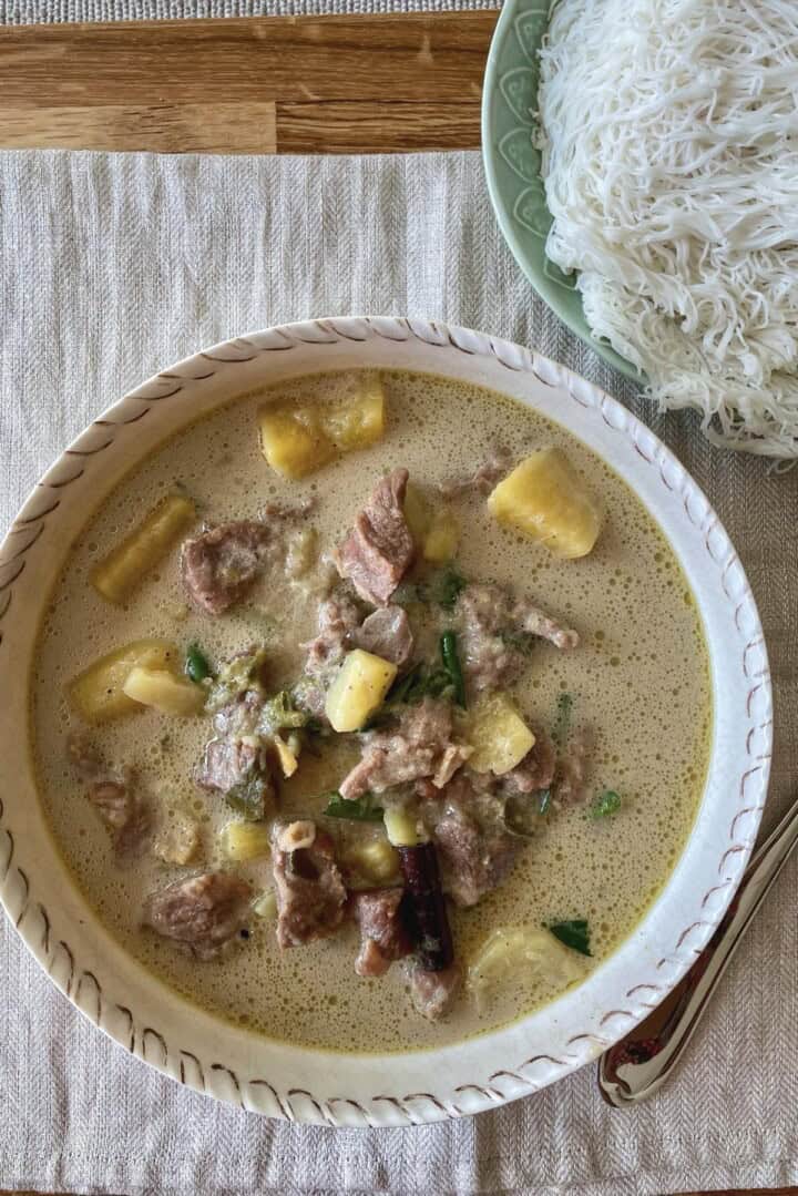 Boneless mutton stew with potatoes coconut milk served in a wide bowl.