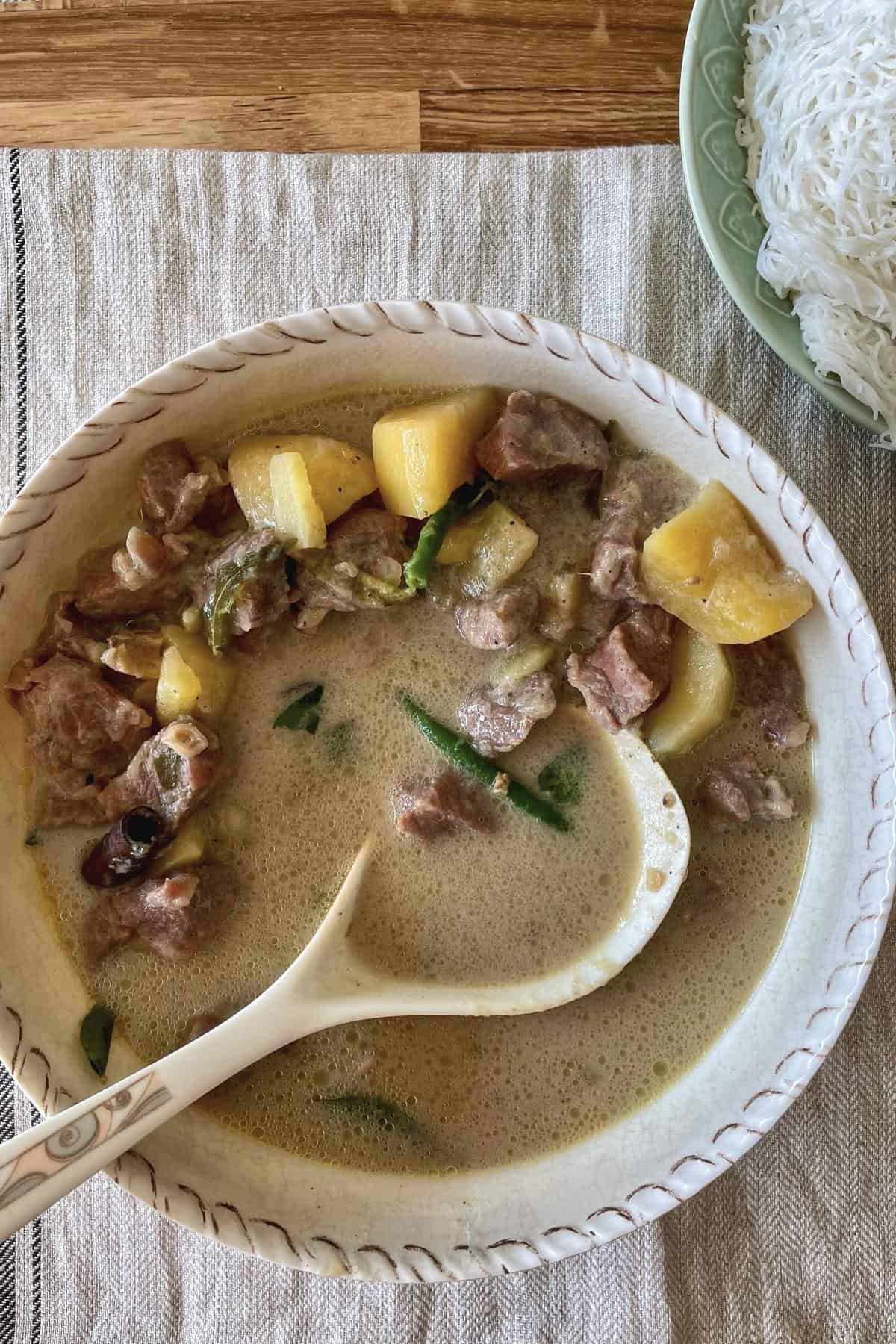 mutton stew in a bowl with serving spoon.