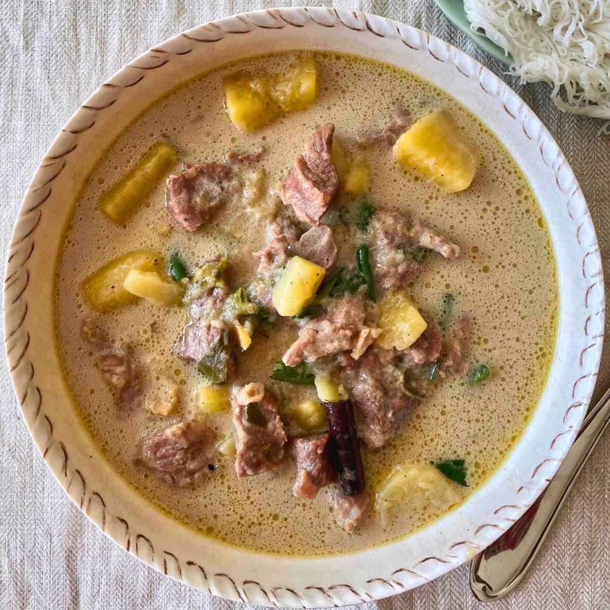 A bowl of kerala style mutton stew with potatoes.