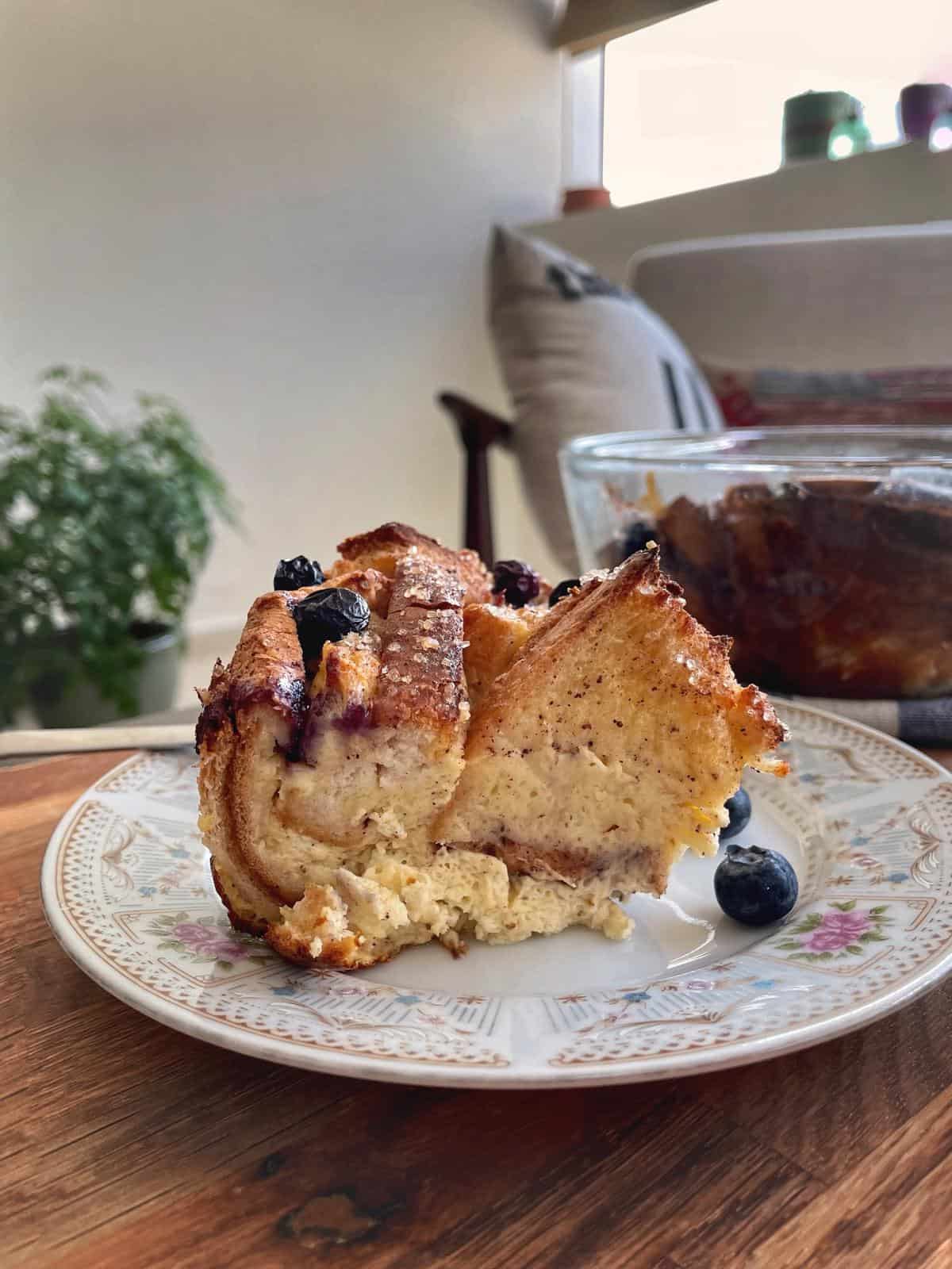 baked french toast casserole portion on a plate with blueberries.