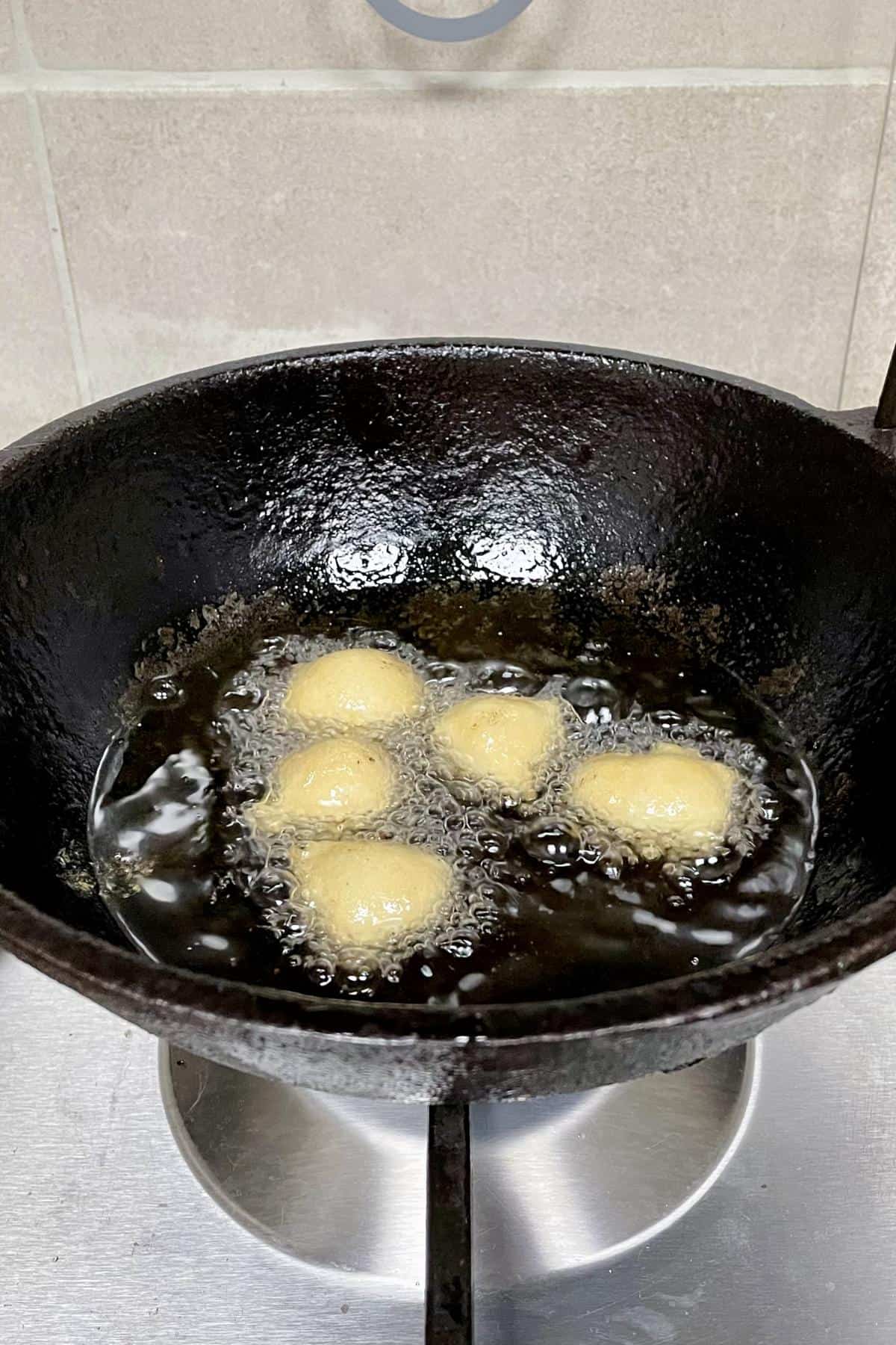 Frying baray in oil in a kadai.