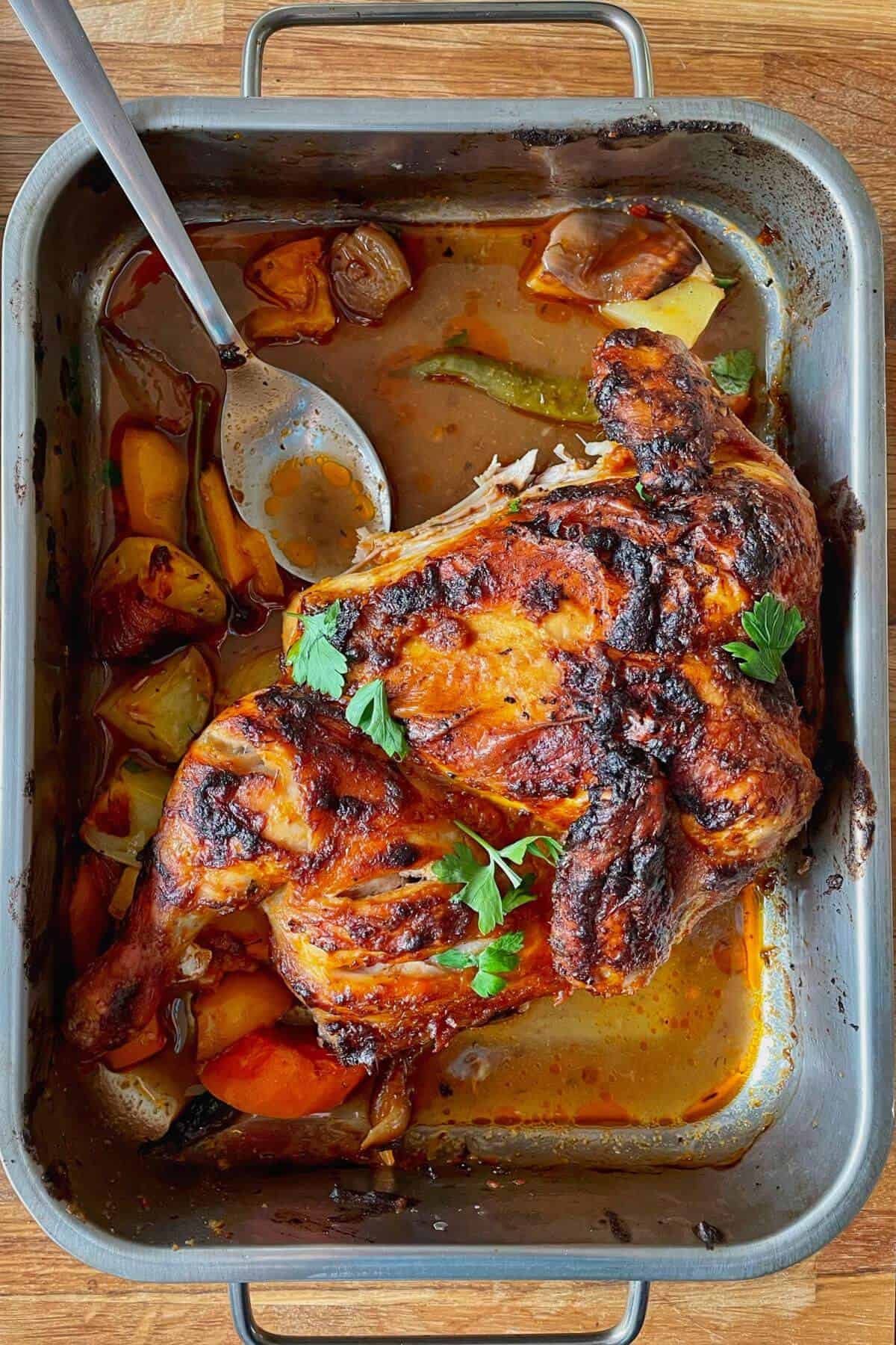 baked chicken in roasting tin with gravy.