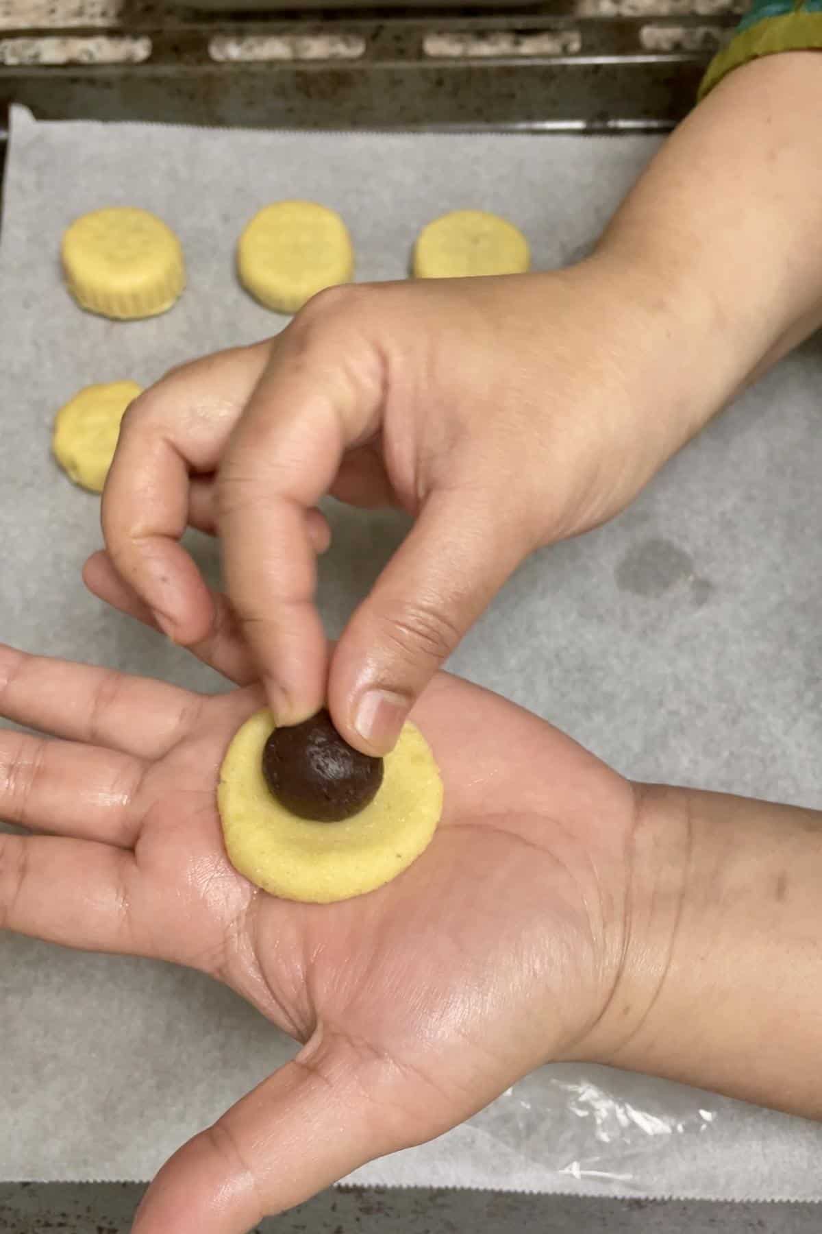 Shaping date stuffed maamoul in hand.