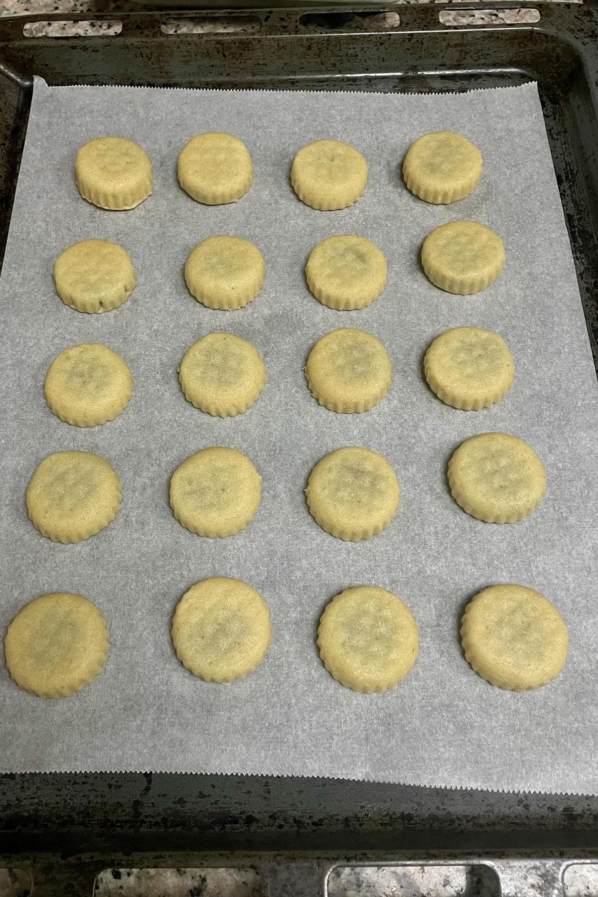 Shaped maamoul cookies on a lined baking tray ready to bake.