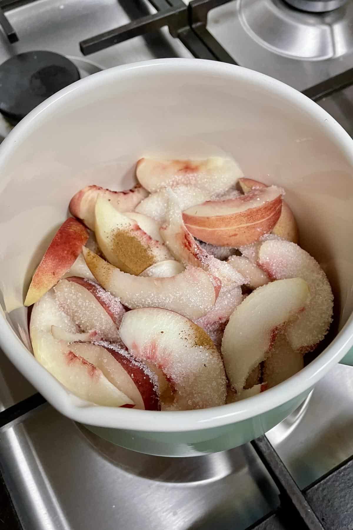 Sliced nectarines with spice and sugar in a saucepot. 