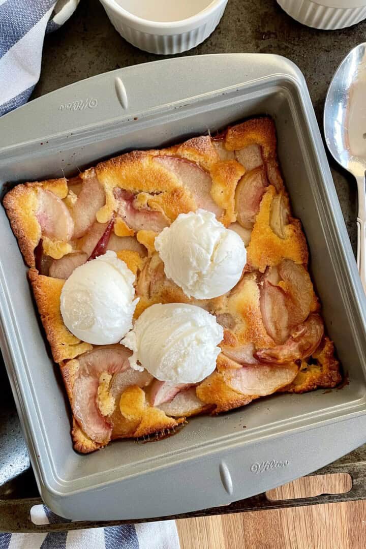 Warm nectarine cobbler topped with scoops of vanilla ice cream.