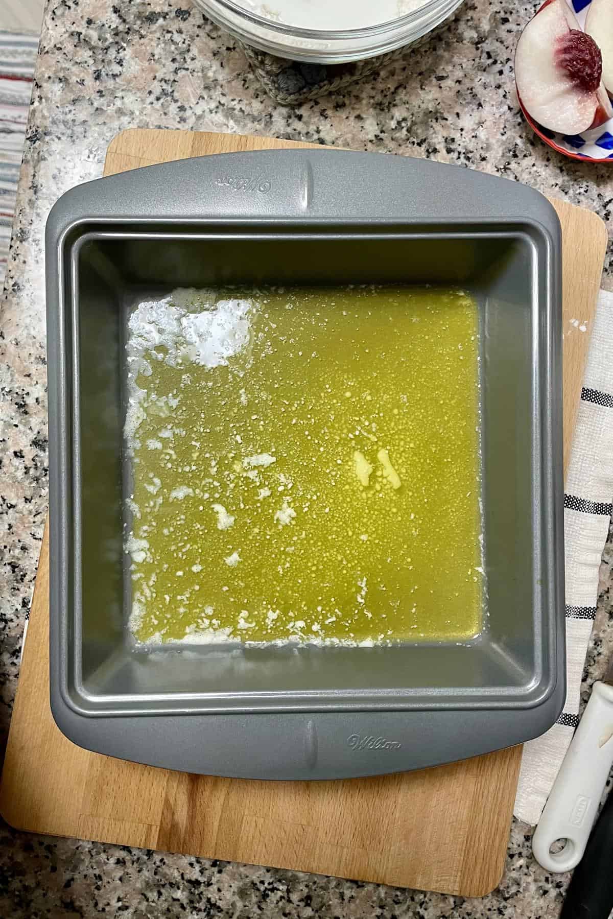 Melted butter in a baking dish.