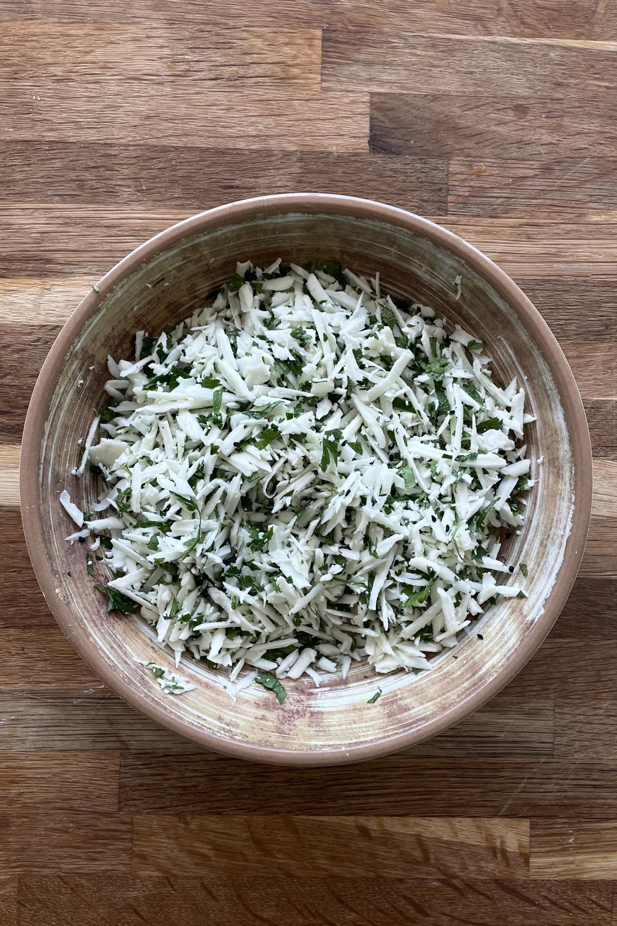 A bowl of halloumi cheese sambousek filling mixture.